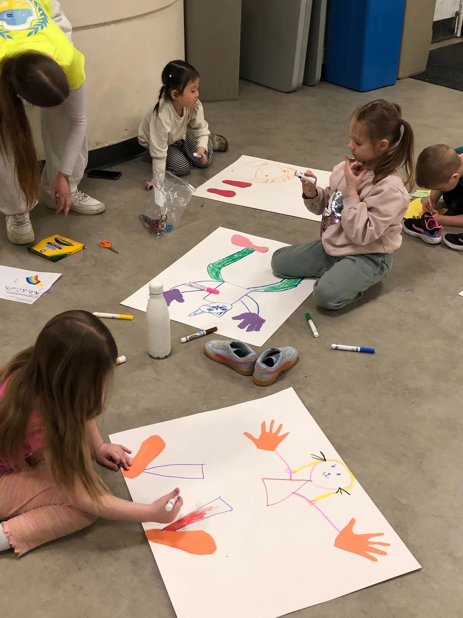 Laurus March Break campers drawing colourful life-size portraits indoors